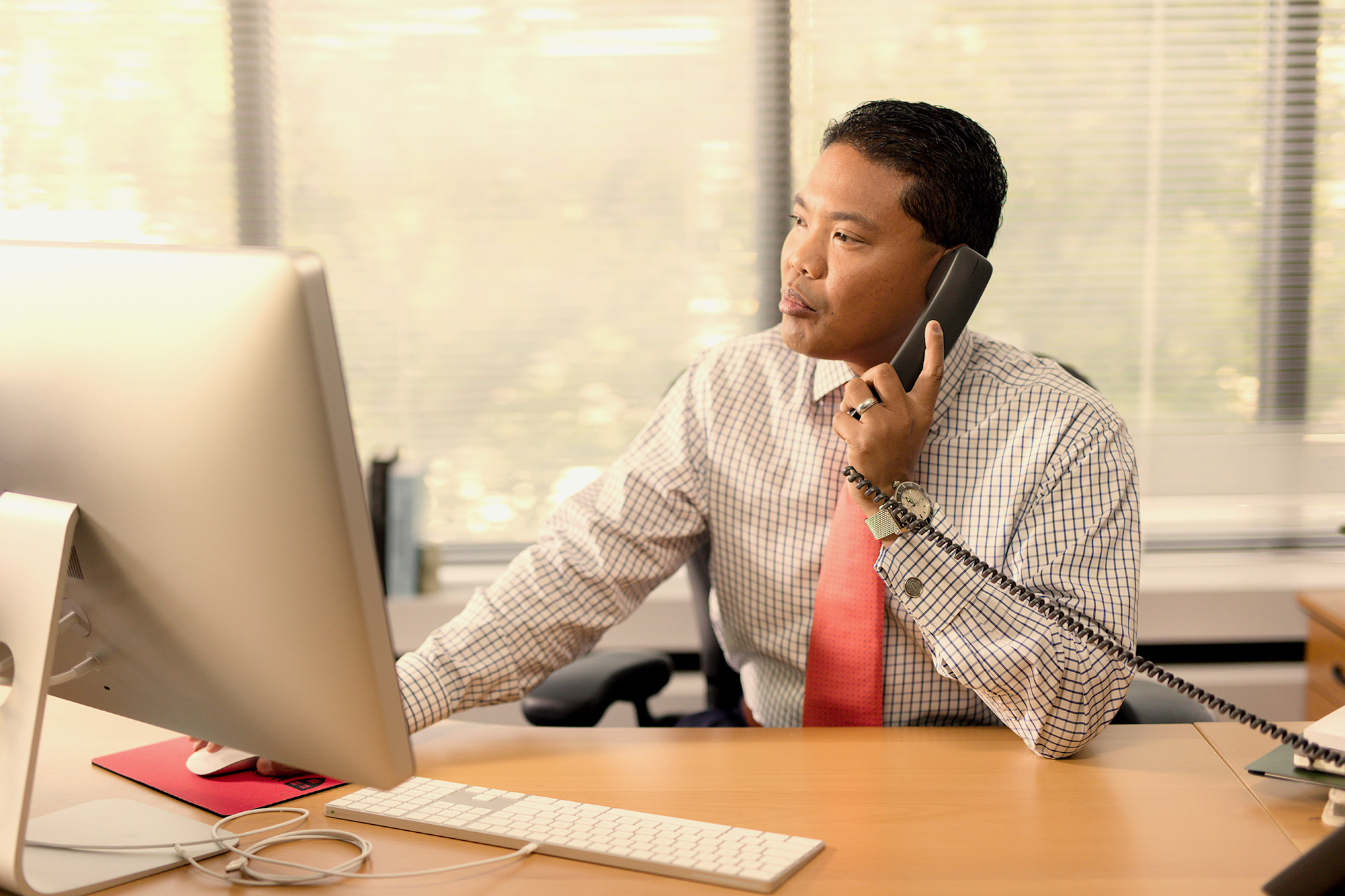 man at desk negotiating over the phone