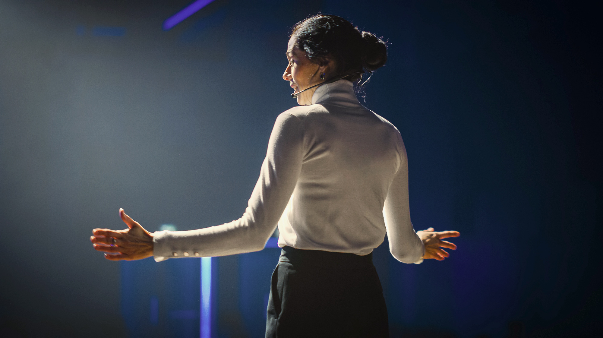 female standing on stage giving speech