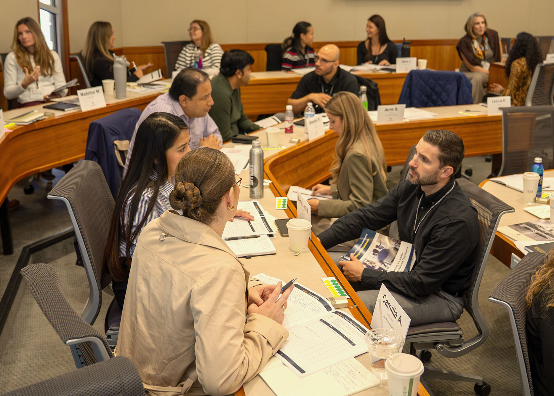 A group of Harvard Professional & Executive Development participants talk in small groups during class.