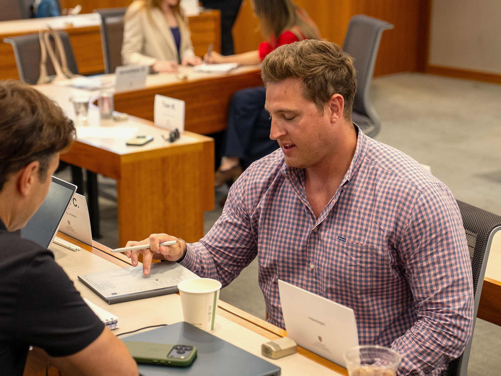 Two Harvard Professional & Executive Development participants work together in class.