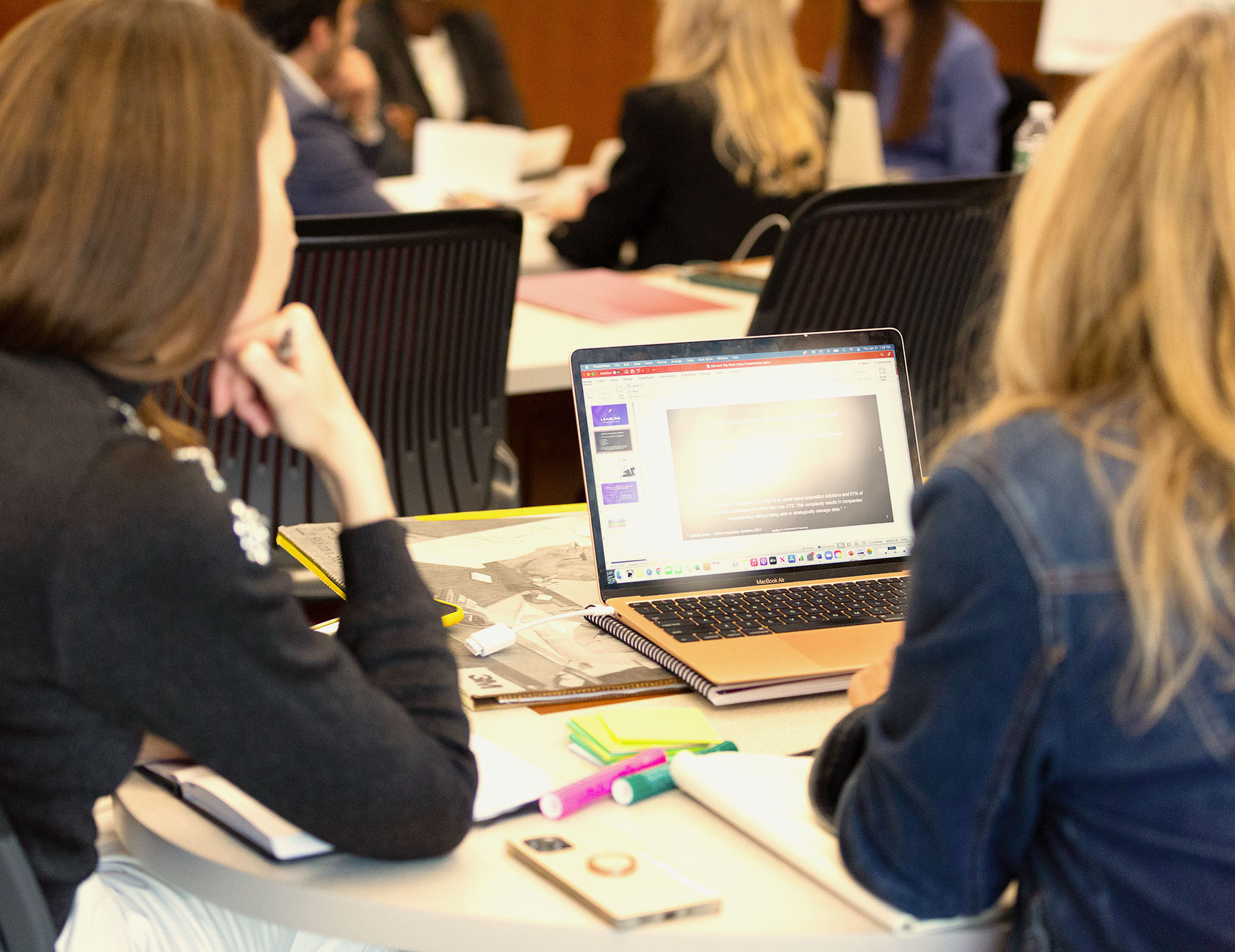 Two women look at a laptop screen.