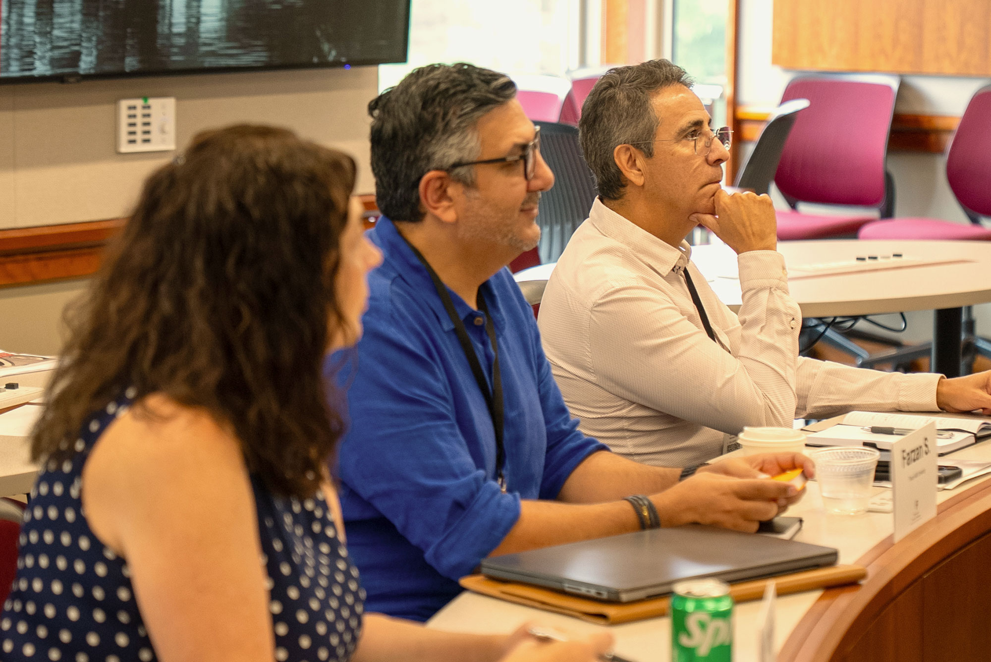 Three Harvard Professional & Executive Development participants listen in class.