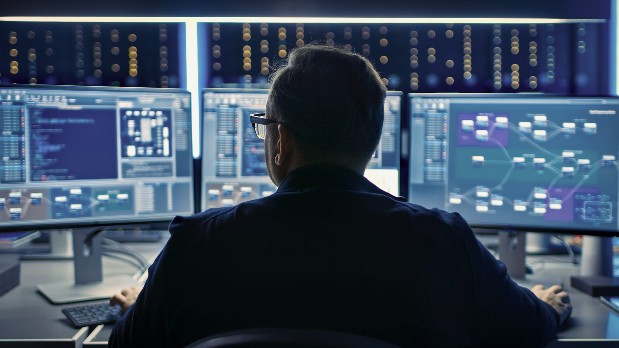 Cybersecurity expert in front of monitors.